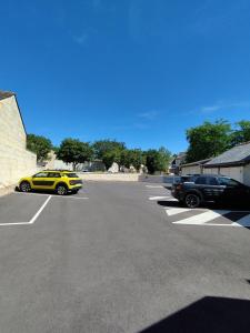 twee auto's staan geparkeerd op een parkeerplaats bij The Originals Access, Hotel Le Canter Saumur in Saumur