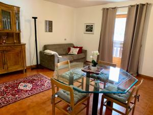 a living room with a glass table and a couch at Cima de’ Piazzi Apartment in Isolaccia