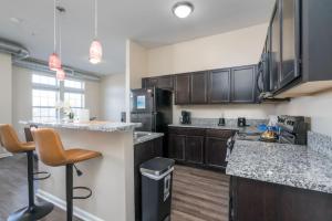 a kitchen with black cabinets and a counter top at Lovely 3BD 3BA Downtown Indy in Indianapolis