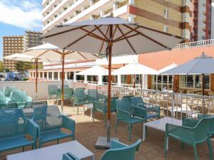 a group of chairs and tables with umbrellas at Hotel Caballo de Oro in Benidorm