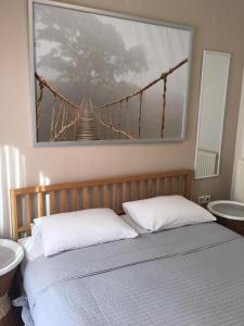 a picture of a suspension bridge hanging above a bed at Seaflows Apartments #3 in Paralia Katerinis