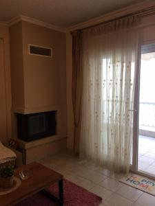 a living room with a fireplace and a television at Seaflows Apartments #3 in Paralia Katerinis