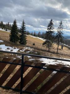 a fence with a view of a field and trees at Hotel Restauracja U Guta in Klikuszowa