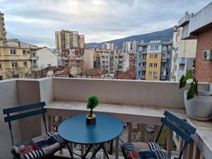 a table and chairs on a balcony with a view at D&D Centar Apartment in Skopje