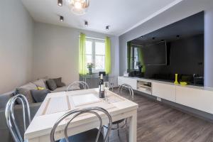 a living room with a table with chairs and a tv at HILLWOOD Apartment in Łódź