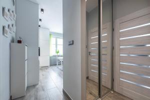 a hallway with a closet with wooden doors at HILLWOOD Apartment in Łódź