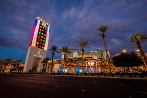 a large building with a casino and palm trees at night at SAHARA Las Vegas in Las Vegas