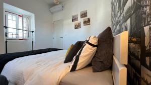um quarto com uma cama com almofadas em Chalet do Descanso em Sintra