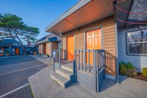 a building with orange doors and stairs next to a street at City Centre Motel by OYO in Seaside
