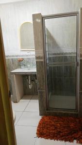 uma casa de banho com um chuveiro, um lavatório e um tapete em Sunrise Hostel Farallon em Río Hato