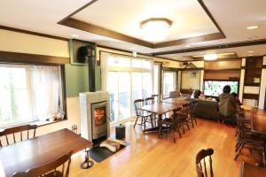 茅野市にあるLarix Tateshina Villa - Vacation STAY 86531vのテーブルと椅子、暖炉が備わる部屋