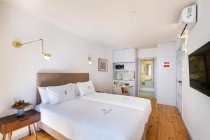 a bedroom with a large white bed with a wooden floor at LP Heritage Apartments next to Braga Cathedral by Sé Apartamentos in Braga