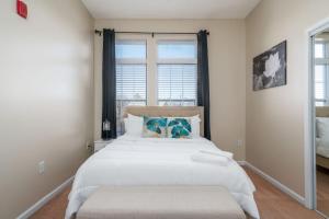 um quarto com uma grande cama branca e uma janela em Private Bedroom Downtown INDY - Shared em Indianápolis