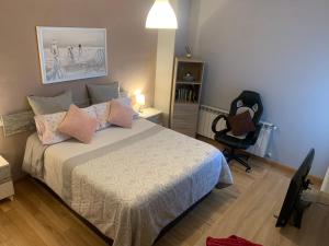 a bedroom with a bed and a desk and a chair at El encanto de Seseña in Seseña