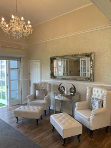 a living room with chairs and a table and a mirror at Regent Hotel in Liverpool