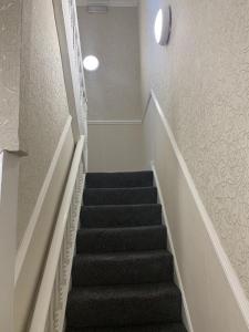 uma escada numa casa com tapete preto em Regent Hotel em Liverpool