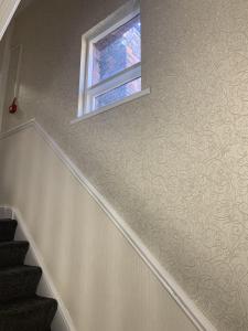 uma escada com uma janela e uma parede com um padrão de redemoinho em Regent Hotel em Liverpool