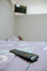 a remote control sitting on top of a bed at Departamentos KAYLU in El Bolsón