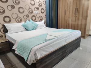 a bed with blue and white pillows on it at Dev Residency in Gurgaon