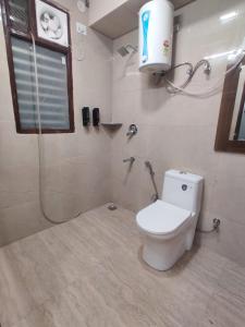 a bathroom with a toilet and a shower and a window at Dev Residency in Gurgaon