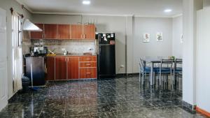 a kitchen with a table and a black refrigerator at Departamentos KAYLU in El Bolsón