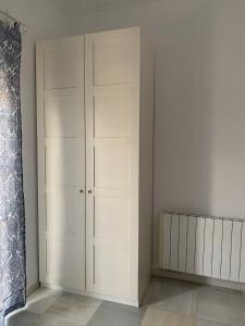 um armário com armários brancos num quarto em Al ladito de Sevilla em Bormujos