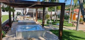 a swimming pool in a backyard with a pergola at Hotel Termas Gravatal in Gravatal