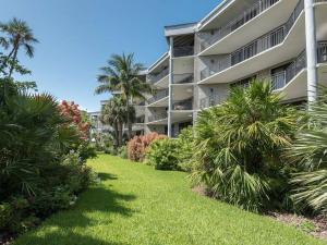 een groot appartementencomplex met palmbomen en een gazon bij Blue Moonshine on the Atlantic in Key West