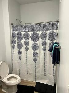 a bathroom with a shower curtain and a toilet at Private Bedroom Fountain Square - Shared in Indianapolis