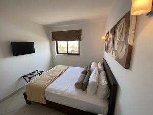 1 dormitorio con 1 cama con sábanas blancas y ventana en Apartments at Melia Beach Resort & Spa, en Santa Maria