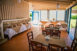 Mesogeios Hotel في ماراثوبوليس: مطعم فيه طاولات وكراسي في الغرفة