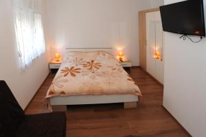 a bedroom with a bed and two lights on two tables at Voshta 2 bedroom apartment in Zadar