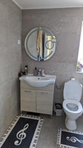 a bathroom with a sink and a toilet and a mirror at Casa Beatrice in Călimăneşti