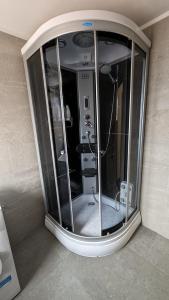 a glass shower in the corner of a bathroom at Casa Beatrice in Călimăneşti