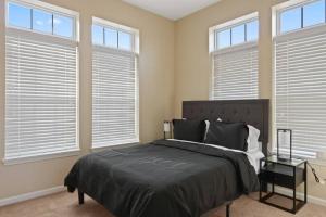 a bedroom with a large bed and windows at Private Bed Downtown INDY - Shared in Indianapolis
