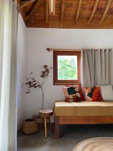 Casa Rosa Atins في أتينز: غرفة نوم بسرير مع نافذة وطاولة