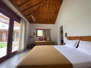 a bedroom with a large bed and a window at Casa Rosa Atins in Atins