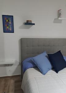 Un dormitorio con una cama con almohadas azules. en supportico home en Nápoles