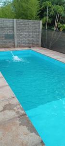 una piscina de agua azul en un patio en Sara Home en Garupá
