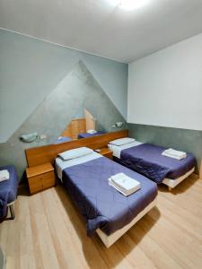 Habitación con 3 camas en una habitación en Albergo Baffo, en Chiuro