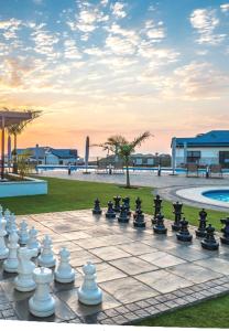 un tablero de ajedrez grande en un patio con piscina en BALLITO HILLS, 1 bedroom apartment en Ballito