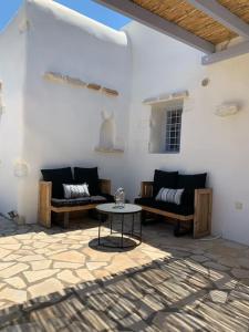 a living room with two couches and a table at Villa Laugh, on The Limnes Beach in Kampos Paros