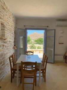 a dining room with a table and chairs and a window at Villa Laugh, on The Limnes Beach in Kampos Paros