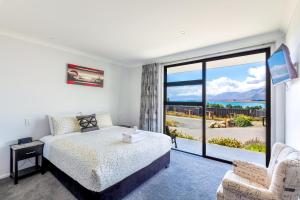 a bedroom with a bed and a large window at Roto View - Beautiful views of Lake Tekapo in Lake Tekapo