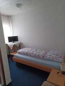 1 dormitorio con cama y mesa con ordenador portátil en Gasthaus zur Linde, en Staufenberg