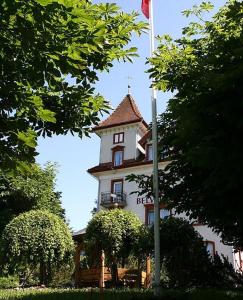 ein Gebäude mit einem Turm mit einer Flagge davor in der Unterkunft Hotel Restaurant Belvedere in Weissbad