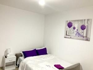 a bedroom with a bed and a painting on the wall at Apartament BriFla Comfort Mureș in Târgu-Mureş