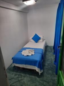 a small bedroom with a bed with a blue blanket at Cabana in poiana padurii in Recaş