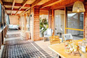 eine Veranda eines Holzhauses mit einem Tisch in der Unterkunft Naturhaus Luminus in Bad Aibling
