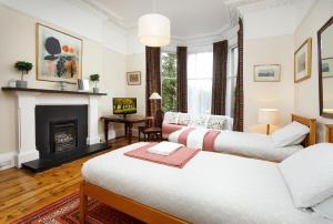 a living room with two beds and a fireplace at Sheen's House in Edinburgh